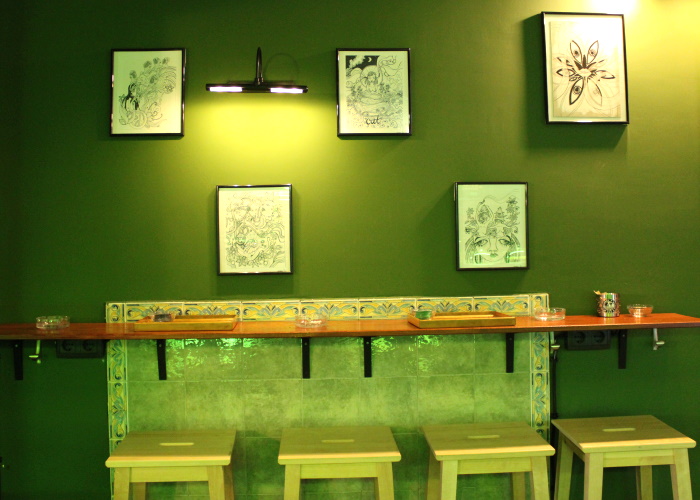 One of the seating areas with row of stools against the wall and small table